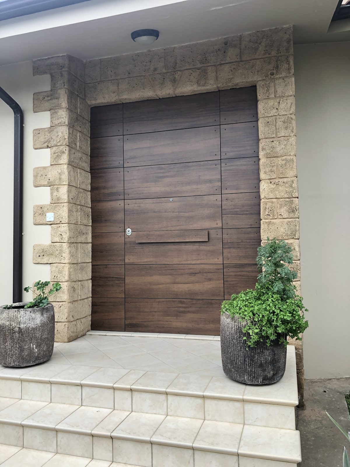Oversized timber entrance gate set into a stone facade